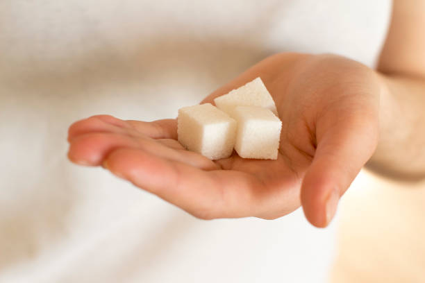 istock young woman holding sugar cubes 1201446053