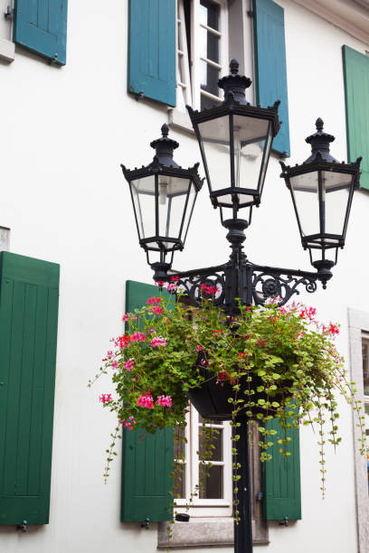 Lantern with flowers in Ratingen, North Rhine Westphalia. facade with shutters in background