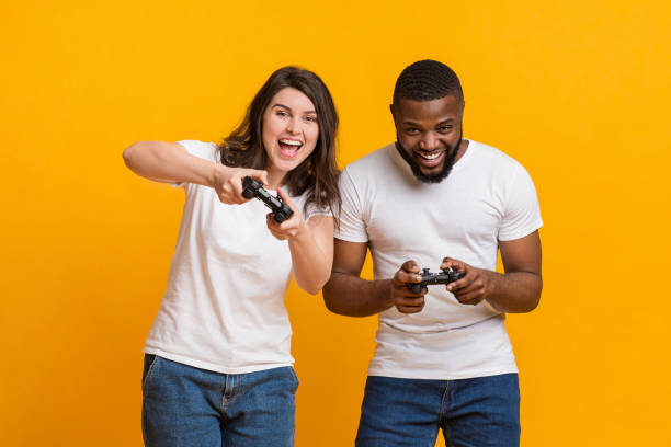 istock Joyful interracial couple holding joysticks competing each other in video games 1201448949