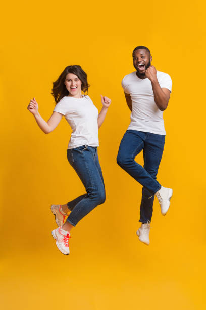 istock Joyful interracial couple jumping in air and shouting with excitement 1201449770