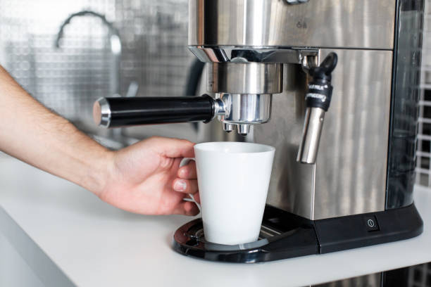 istock Guy prepare delicious aromatic coffee in a coffee machine. A simple way to make coffee 1201450026