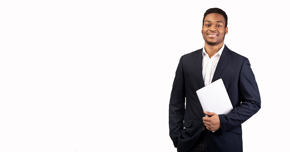 Elegant Manager. Confident black man standing with laptop isolated over white studio wall. Empty space, panorama