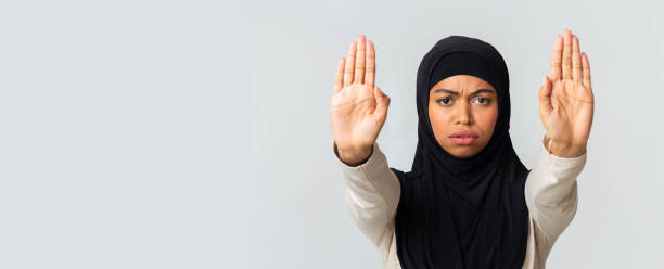istock Serious afro islamic girl making stop hand gesture with opened palms 1201450349
