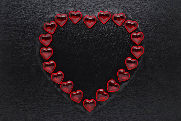 istock valentines day background with red hearts on black 1201451594