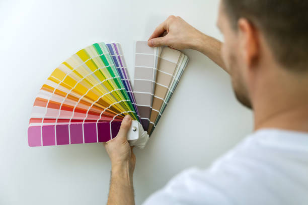 istock man selecting paint color from swatch for room wall 1201453347