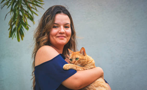istock Beautiful girl with a ginger cat on her lap 1201453496