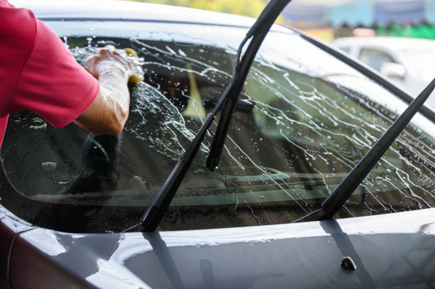 istock Worker washing and rubbing car with sponge and water 1201453663
