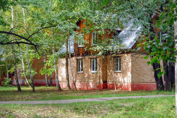 istock Red brick house stands among the trees 1201454385