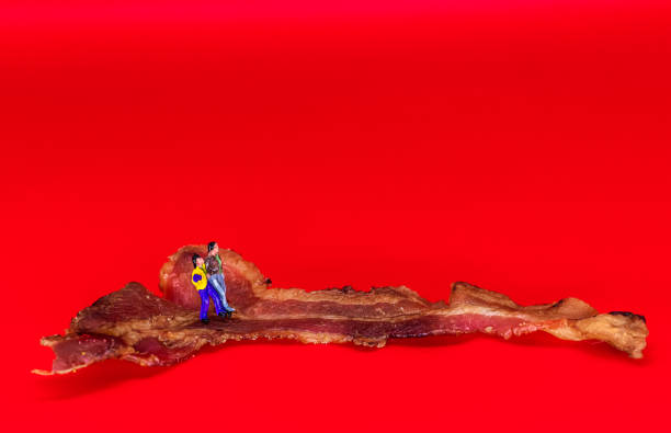 istock Couple walks along a slice of cooked bacon, anthropomorphic 1201454701