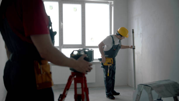 istock Repairing on the draft apartment - two men workers working indoors 1201456082