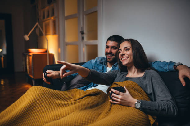 couple at home romantic couple watching television at home blanket stock pictures, royalty-free photos & images