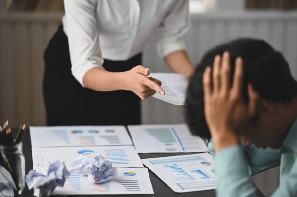 cropped tiro de mulher seriamente executiva enquanto reclamava com seu empregado que tem sentado na mesa de trabalho. - women failure nerd talking - fotografias e filmes do acervo