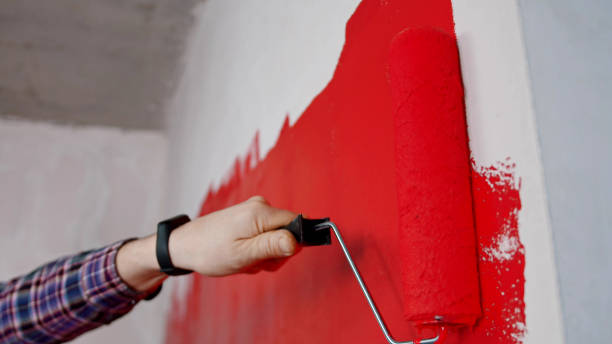 istock Covering wall in red paint in new apartment 1201458108