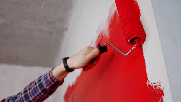istock Covering wall in bright red paint in new apartment 1201458125