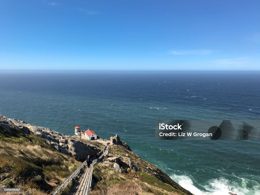 Steep stairs lead down a rocky path to the Point Reyes lighthouse with the Pacific Ocean in the background  in Northern California; landscape Barren Stock Photo
