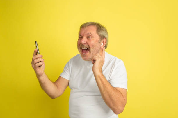 istock Caucasian senior man's portrait isolated on yellow studio background 1201460920