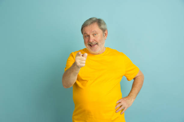 istock Caucasian senior man's portrait isolated on blue studio background 1201460987