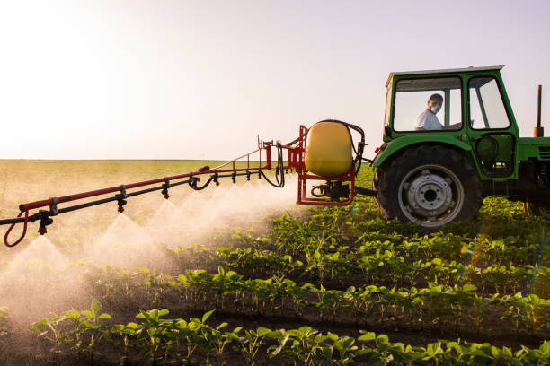 трактор распыления пестицидов на соевом поле с опрыскиватель весной - spraying crop sprayer farm agriculture стоковые фото и изображения