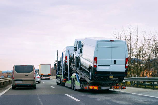 Minivan carrier transporter truck in road Auto vehicles Minivan carrier transporter truck in road. Auto vehicles hauler on driveway. European van transport logistics at haulage work transportation. Heavy haul car trailer with driver on highway. car transporter truck small car stock pictures, royalty-free photos & images