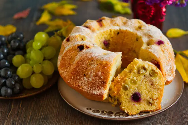 Homemade bundtcake with autumn grapes on a table with fall decoration