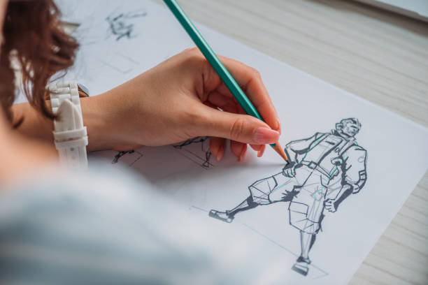 selective focus of illustrator drawing cartoon character on paper - human hand pencil women sketching imagens e fotografias de stock