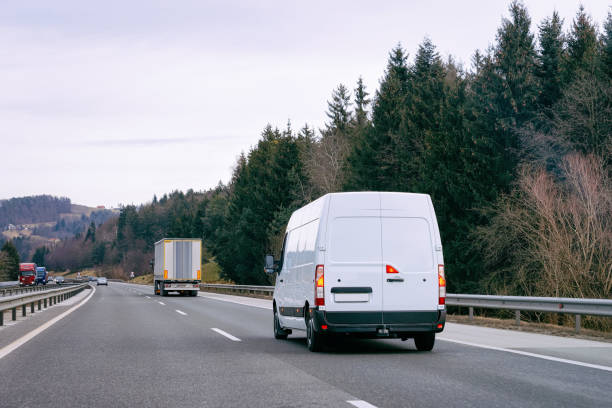 istock White Minivans on road van transport logistics 1201467206