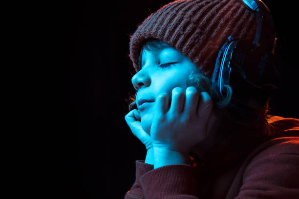 istock Caucasian boy's portrait isolated on dark studio background in neon light 1201467372