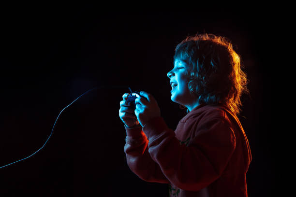 istock Caucasian boy's portrait isolated on dark studio background in neon light 1201467373