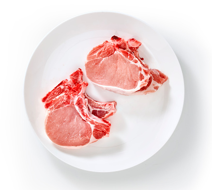 fresh raw pork chop from supermarket  isolated on white