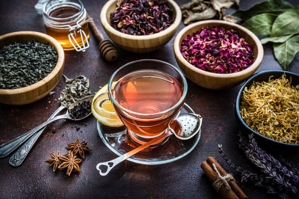 istock Tea cup with various dried tea leaves and flowers shot from above on brown table 1201470044
