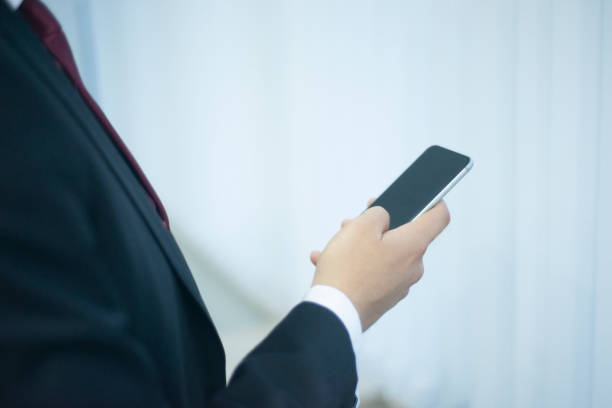 istock Close-up shot of unrecognizable young businessman using phone in office 1201472087