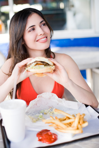 beautiful young latin girl eating fast food