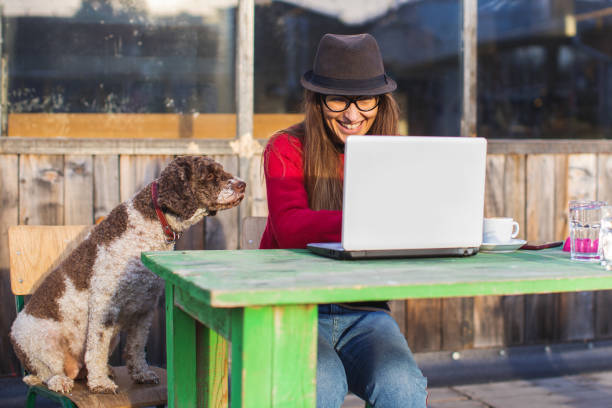 istock woman working with cute dog on laptop 1201478450