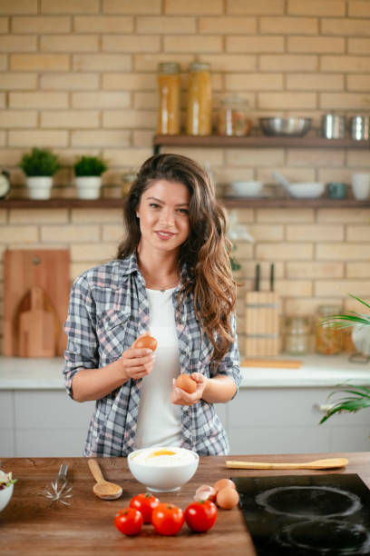 istock Young woman preparing food in kitchen 1201478469