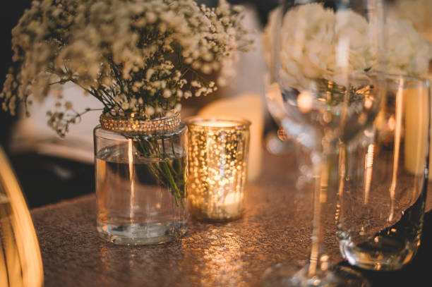 istock fine dining table decoration setup with flowers in vases and wine glass , candle light 1201479211