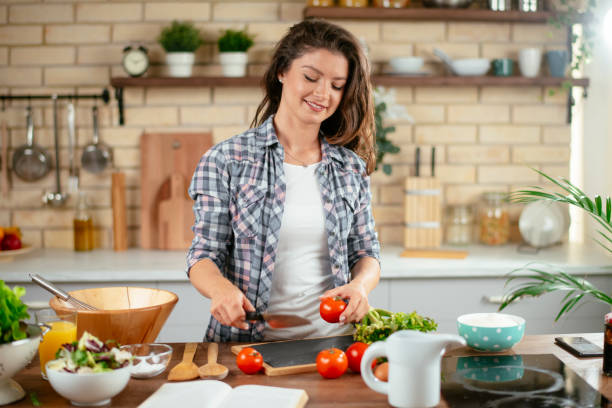 istock Young woman preparing food in kitchen 1201479802