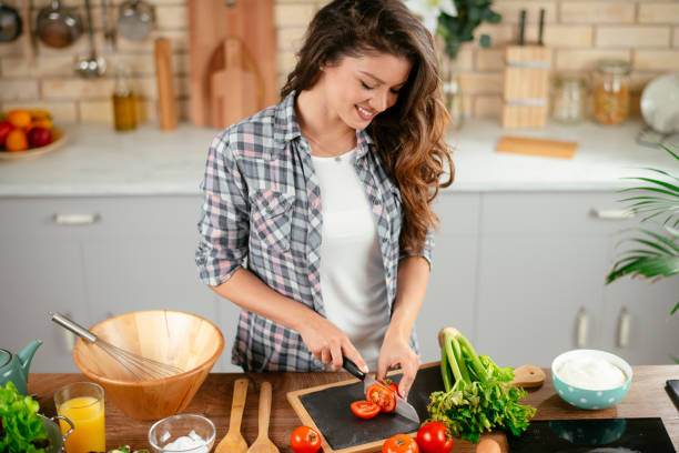 istock Young woman preparing food in kitchen 1201479850
