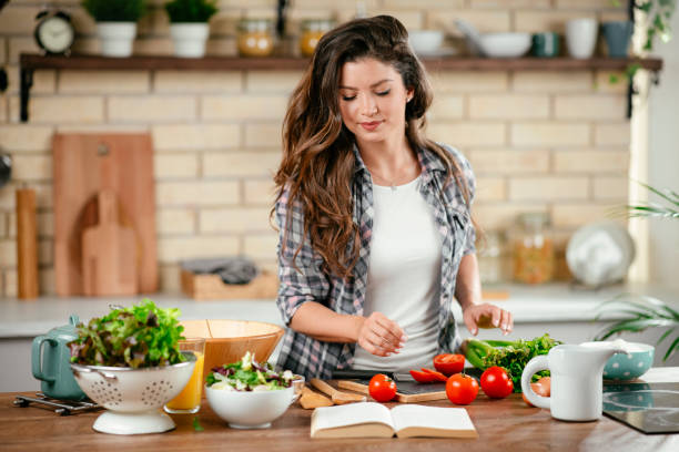 istock Young woman preparing food in kitchen 1201480031