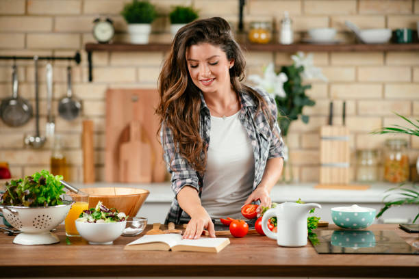 istock Young woman preparing food in kitchen 1201481564