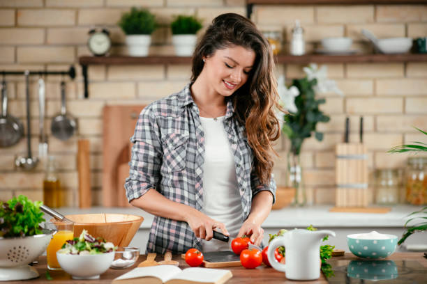 istock Young woman preparing food in kitchen 1201481727