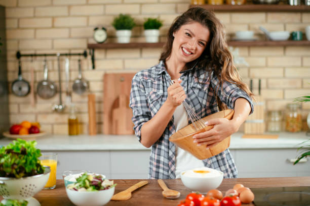 istock Young woman preparing food in kitchen 1201482607