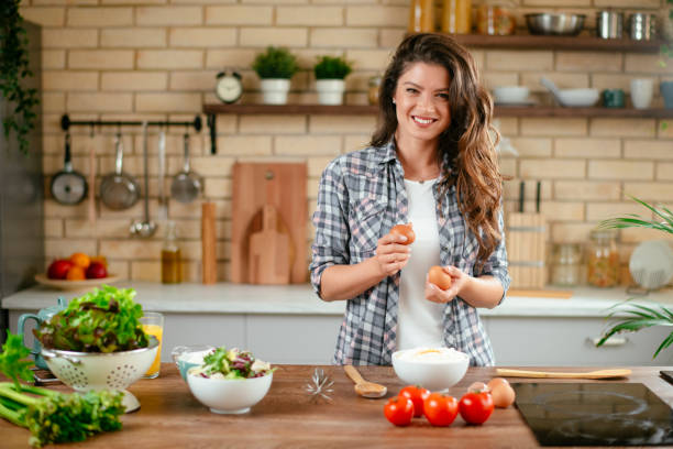 istock Young woman preparing food in kitchen 1201482768