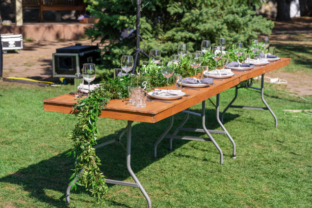 istock Preparing for an open-air party. Decorated with fresh flowers served tables. Table number. Decoration Details 1201483342