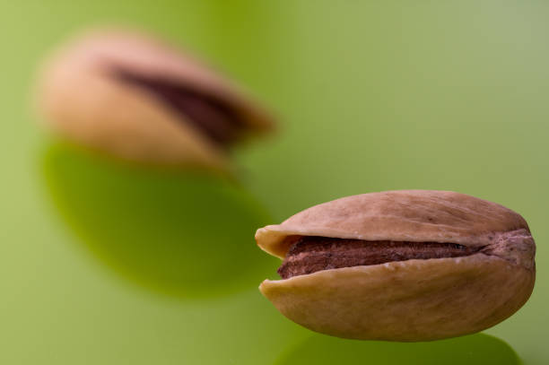 Two pistachios on green glass, macro