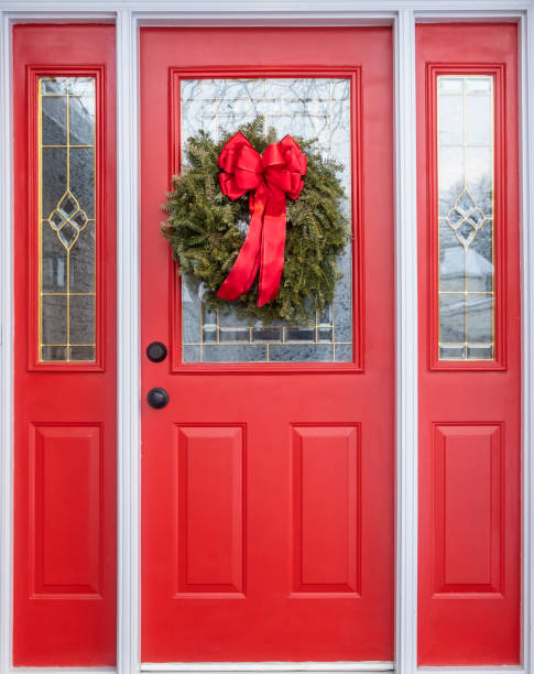istock Red Front Door Decorated with a Christmas Pine Wreath and Red Bow 1201489801