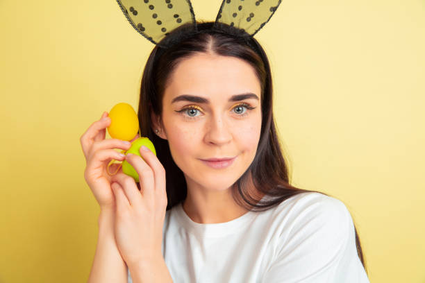 femme de lapin de pâques avec des émotions lumineuses sur le fond jaune de studio - easter rabbit bizarre women photos et images de collection