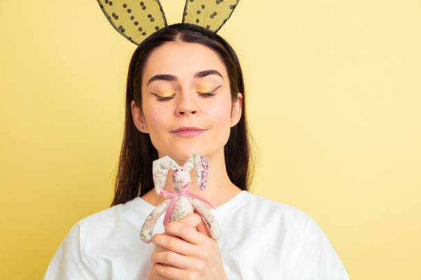 femme de lapin de pâques avec des émotions lumineuses sur le fond jaune de studio - easter rabbit bizarre women photos et images de collection