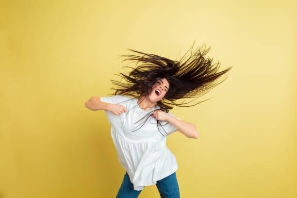 istock Easter bunny woman with bright emotions on yellow studio background 1201490536
