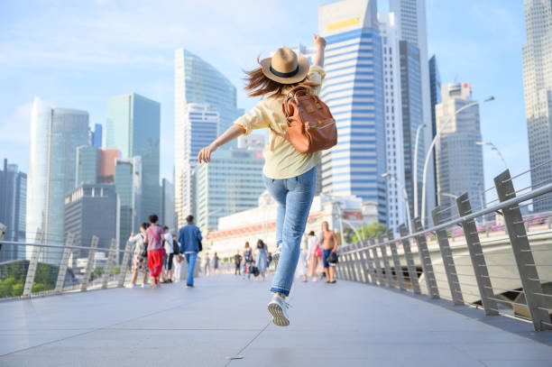 Young woman jumping in city, happiness and vacation concept stock photo