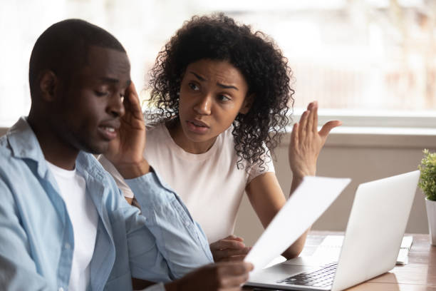 istock Multiethnic couple disputer managing household paperwork at home 1201492823